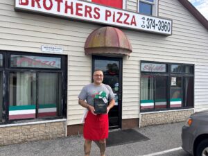 Andy Illiano of Brother's Pizza in Manchester poses with his thank you for doing business in Carroll bag.