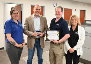 Image of the Econ Dev team and Doug Wagner, CEO and Glen Nightingale, Site Director, Caldera Manufacturing Group with the Pillar Award and Certificate.