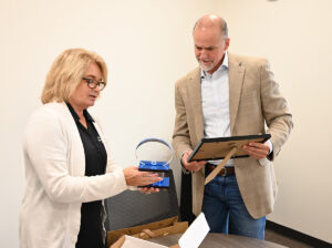 Image of Economic Development Deputy Director, Paige Sunderland presents the Pillar Award to Doug Wagner, CEO of Caldera Manufacturing.