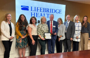 Image of Garrett Hoover, President and team presented with the Pillar Award by the Econ Dev representatives.