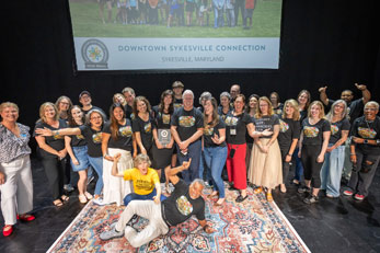 Image of people on stage celebrating Downtown Sykesville award